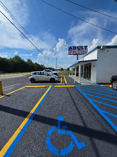 Blue ADA handicap stall and yellow line striping on a newly sealcoated parking lot